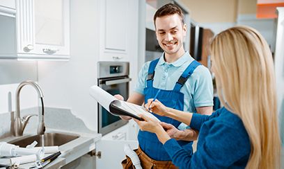 Male Plumber And Female Customer In The Kitchen